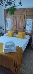 2 Betten in einem Zimmer mit gelben Kissen in der Unterkunft El Cantón in Bogarra