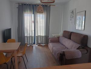 a living room with a couch and a table at Apartamentos Cala San Pedro in Las Negras