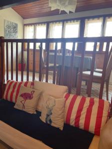 un sofá con almohadas en una habitación en Rare 2 bedroom with private beach on Lake Annecy en Doussard
