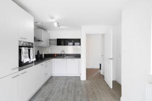 a white kitchen with white cabinets and a sink at 7 bed, 5 bedroom, Contractors, Peterborough area in Peterborough