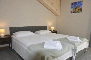 um quarto com 2 camas e toalhas brancas em Šušvė em Plinkaigalis