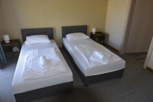 2 letti in camera d'albergo con lenzuola bianche di Šušvė a Plinkaigalis
