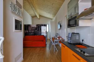 a kitchen and a living room with a red couch at Eco Venice in Favaro Veneto