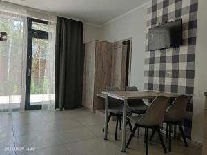 uma sala de jantar com uma mesa e cadeiras e uma televisão em Apartamenty Wilczyca em Wilczyn