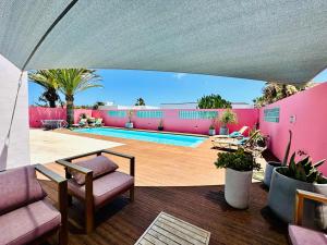un patio avec une table et des chaises et une piscine dans l'établissement Casa Color, à Corralejo