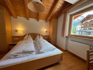a bed in a room with a large window at Residence Aster in Solda