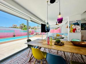 un salon avec une table et des chaises et une piscine dans l'établissement Casa Color, à Corralejo