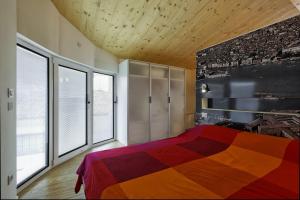 a bedroom with a colorful bed and large windows at Eco Venice in Favaro Veneto