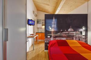 a bedroom with a colorful bed and a kitchen at Eco Venice in Favaro Veneto