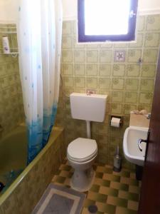 a bathroom with a toilet and a tub and a sink at Ipsos Apartment Mari in Kechria