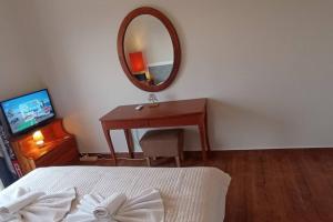 a bedroom with a bed and a desk and a mirror at Ipsos Apartment Mari in Kechria
