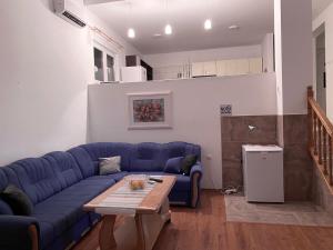 a living room with a blue couch and a table at Villa Alvin in Kosor