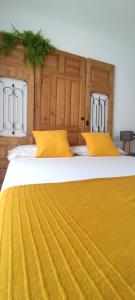 two large beds with yellow pillows on them at El Cantón in Bogarra
