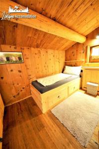 a room with a bed in a wooden cabin at Chalet Heaven Mottolino in Livigno