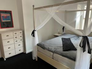 een slaapkamer met een hemelbed en een dressoir bij Hubertushaus in Burgen