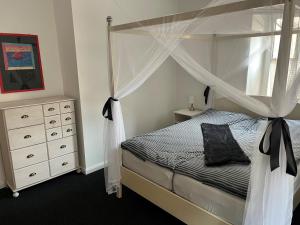 a bedroom with a canopy bed and a dresser at Hubertushaus in Burgen