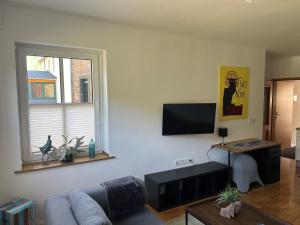 een woonkamer met een bank en een flatscreen-tv bij Hubertushaus in Burgen