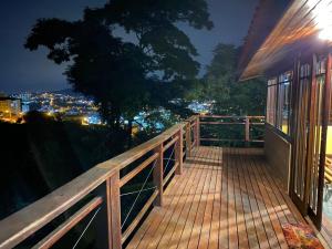 a deck with a view of a city at night at Chalé com vista incrível in São Roque