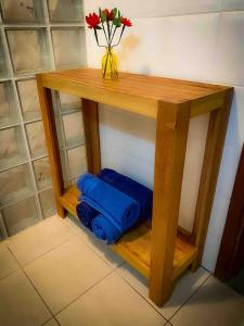 a wooden shelf with blue towels and a vase of flowers at Chalé com vista incrível in São Roque