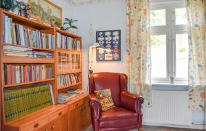 a living room with a chair and a book shelf at Lovely Home In Brkne-hoby With Wifi in Bräkne-Hoby