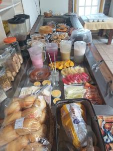 un buffet con muchos tipos diferentes de pan y repostería en Pousada Kanamary, en Praia do Frances