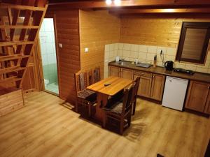 eine Küche mit einem Holztisch im Zimmer in der Unterkunft Domki Letniskowe Kama 514 - 280 - 102 in Solina