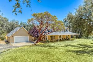 a large yellow house with a garage at Wooded Bliss in Mariposa