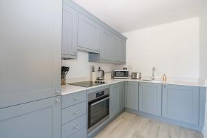 a white kitchen with white cabinets and appliances at Robins Nest in Fareham