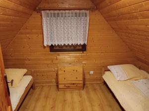 a bedroom with two beds in a log cabin at Domki Letniskowe Kama 514 - 280 - 102 in Solina