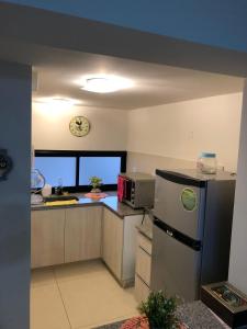 a kitchen with a refrigerator and a clock on the wall at Departamento del Parque in San Miguel de Tucumán