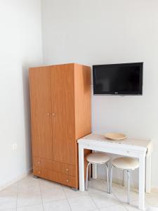 カヴァラにあるLina's Homeの白いテーブル(椅子2脚付)、壁掛けテレビ