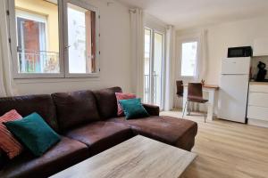 een woonkamer met een bruine leren bank en een tafel bij Appartement en bord de mer 2 in Banyuls-sur-Mer