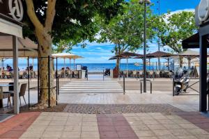 een straat met tafels en stoelen en de oceaan bij Appartement en bord de mer 2 in Banyuls-sur-Mer