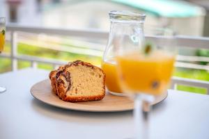 un plato con una rebanada de pan y un vaso de zumo de naranja en Evangelia Rooms & Apartments - A en Asprovalta