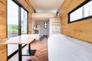 een tiny house met een bed en een bureau bij FUKUOKA FUKUTSU MUNAKATA YUSUKE HOUSE in Kōnominato