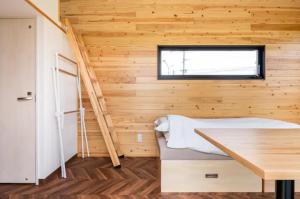 een kleine kamer met een bed en een houten muur bij FUKUOKA FUKUTSU MUNAKATA YUSUKE HOUSE in Kōnominato