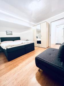 sypialnia z łóżkiem, kanapą i lustrem w obiekcie Gauencenter EG - CharmingStay w mieście Flums