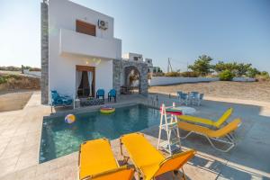 a villa with a swimming pool and yellow chairs at Ciel Blue Villas in Kiotari