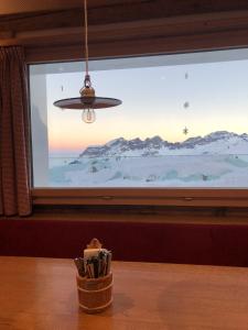 une fenêtre avec vue sur une montagne enneigée dans l'établissement Bärghuis Jochpass - Alpine Hideaway - 2222müM, à Engelberg