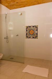 a bathroom with a shower with a mosaic on the wall at Granja 17 de Noviembre in Atyrá