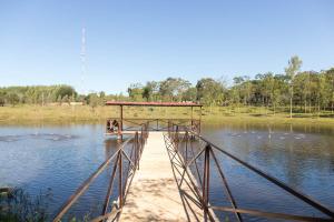 un puente sobre un lago con patos en el agua en Granja 17 de Noviembre, en Atyrá