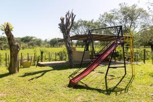 a playground with a red slide in a field at Granja 17 de Noviembre in Atyrá