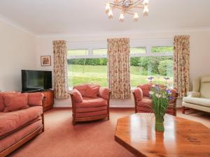 a living room with couches and a tv and a table at Deepdene in Dorchester
