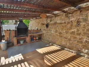 an outdoor patio with a stone wall and a fireplace at Panoramico in Oden