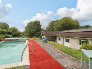 um tapete vermelho ao lado de uma casa com piscina em Deepdene em Dorchester