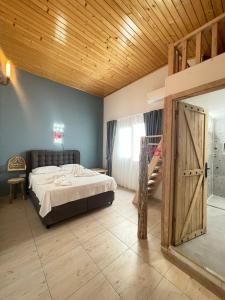 een slaapkamer met een bed en een houten plafond bij Infinity Suites in Fethiye