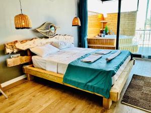 een slaapkamer met een groot bed en een blauwe deken bij Infinity Suites in Fethiye