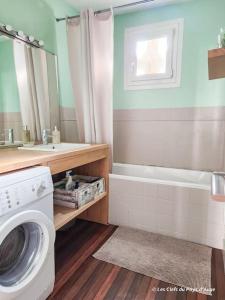 a bathroom with a washing machine and a bath tub at Bel appartement au cœur de Lisieux, parking + wifi in Lisieux
