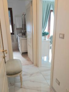 Habitación con vistas a un pasillo con silla y baño. en La Vigna del Vento en Casola di Napoli