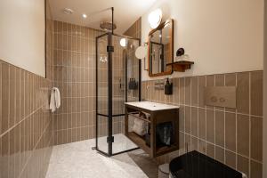 uma casa de banho com um chuveiro e um lavatório. em Grand Joanne em Copenhague